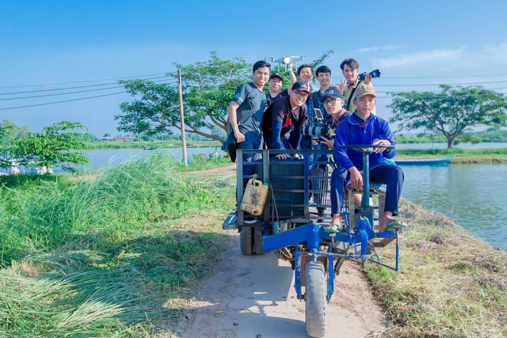 Đoàn quay cùng camera và thiết bị di chuyển tại khu vực ao nuôi ngoài hiện trường.